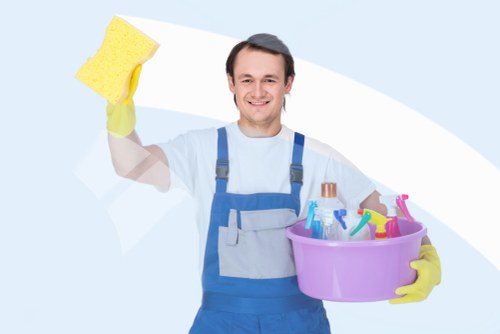 Cleaner wiping dust from window frames and glass in a Merton property